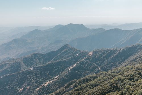 Free Scenic aerial view of lush green mountains blanketed with mist, offering a tranquil natural landscape. Stock Photo