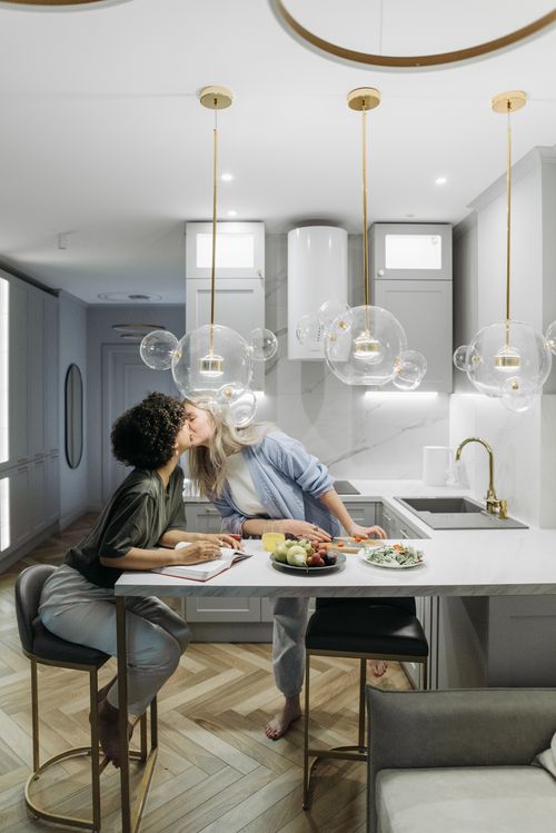 Free A loving couple shares a tender kiss in a stylish and modern kitchen setting. Stock Photo