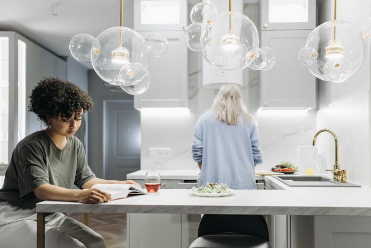 A Woman Reading A Book In The Kitchen