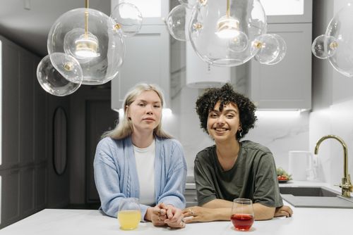 Free A happy LGBTQ+ couple enjoying time together in a stylish kitchen. Stock Photo