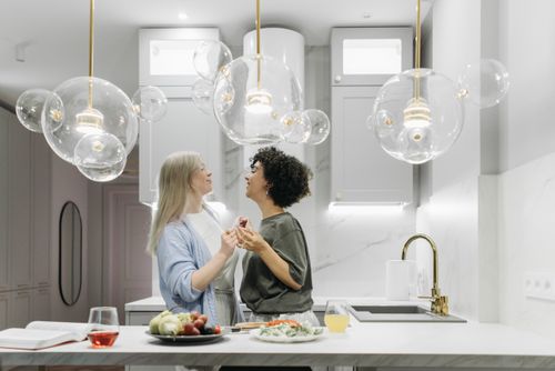 Free A happy couple enjoying sweet moments together in a stylish kitchen. Stock Photo