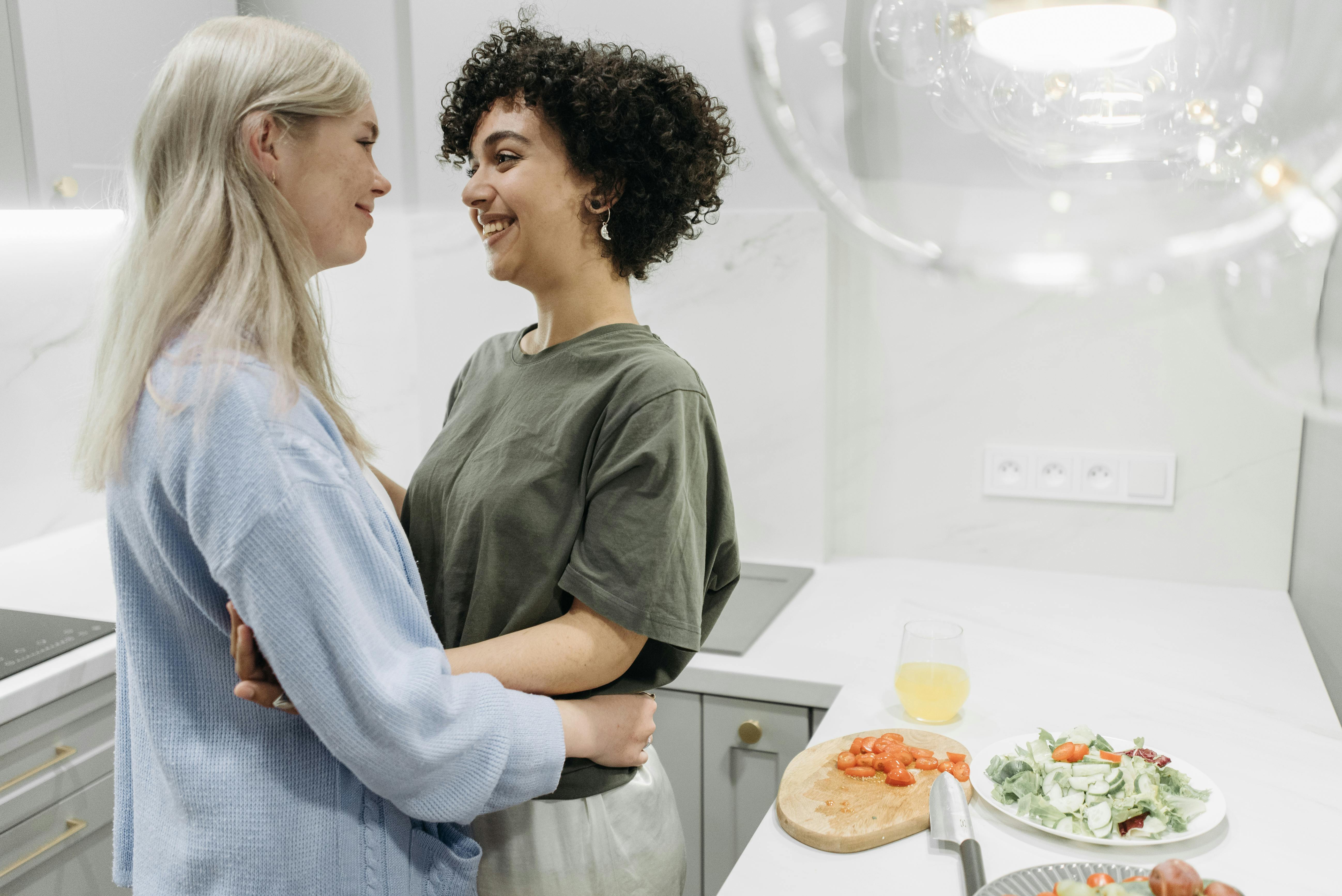 Loving couple embraces in a modern kitchen, sharing a moment of happiness.