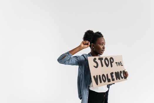Black woman holding a 'Stop the Violence' sign in a peaceful protest setting.