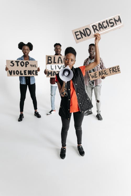 Free Four People Holding Handwritten Protest Posters Stock Photo