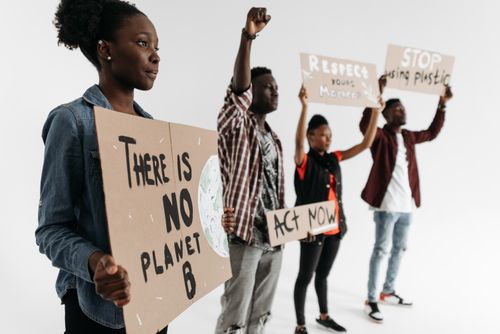 Free Diverse group holding protest signs advocating for climate action with phrases like 'There is No Planet B'. Stock Photo