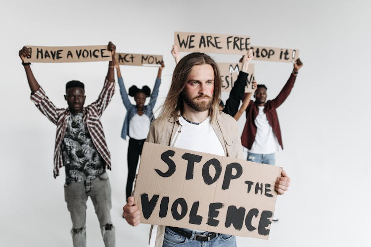 A Group Of People Protesting While Holding Placards