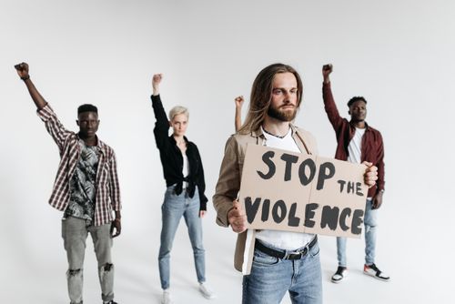 Free A diverse group of people protesting against violence, holding a sign indoors. Stock Photo
