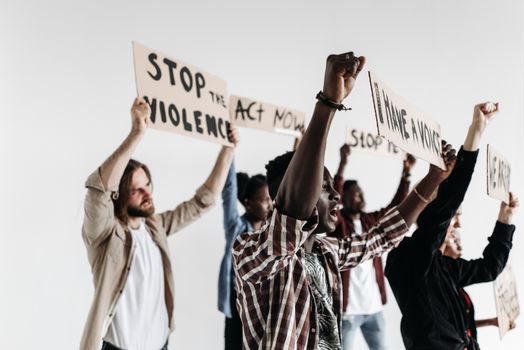 A diverse group of adults passionately protesting against violence with signs.