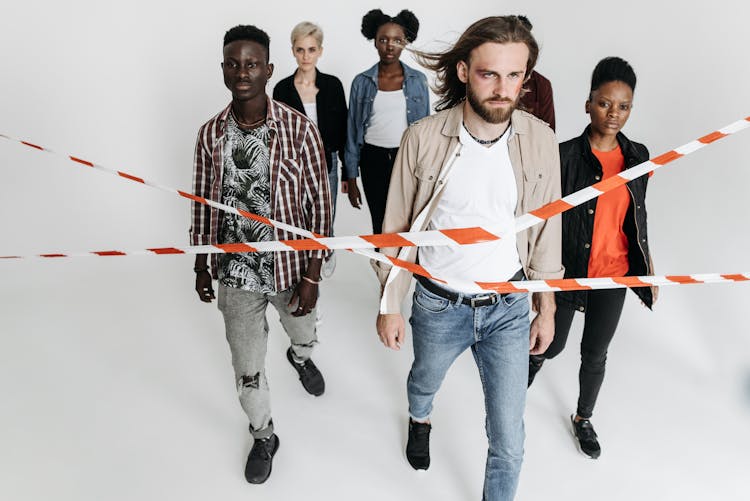 Group Of People Passing A Barricade Tape