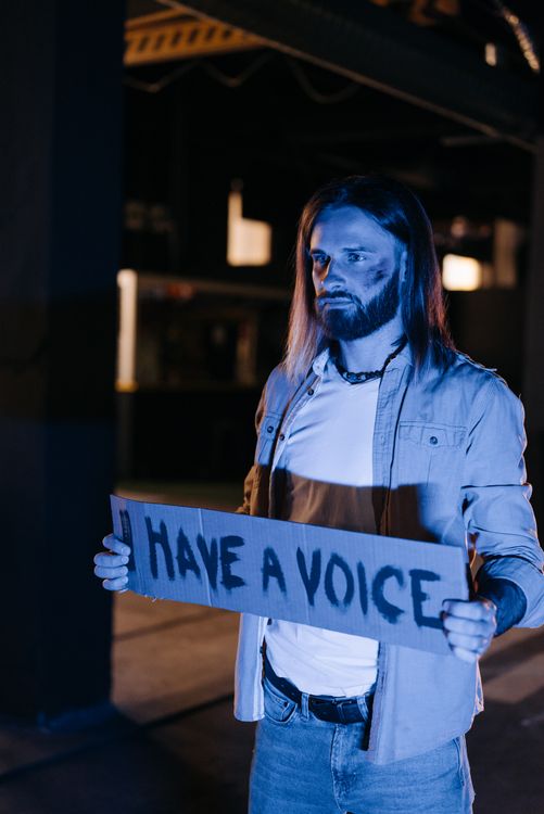 Man Standing and Holding a Protest Sign · Free Stock Photo