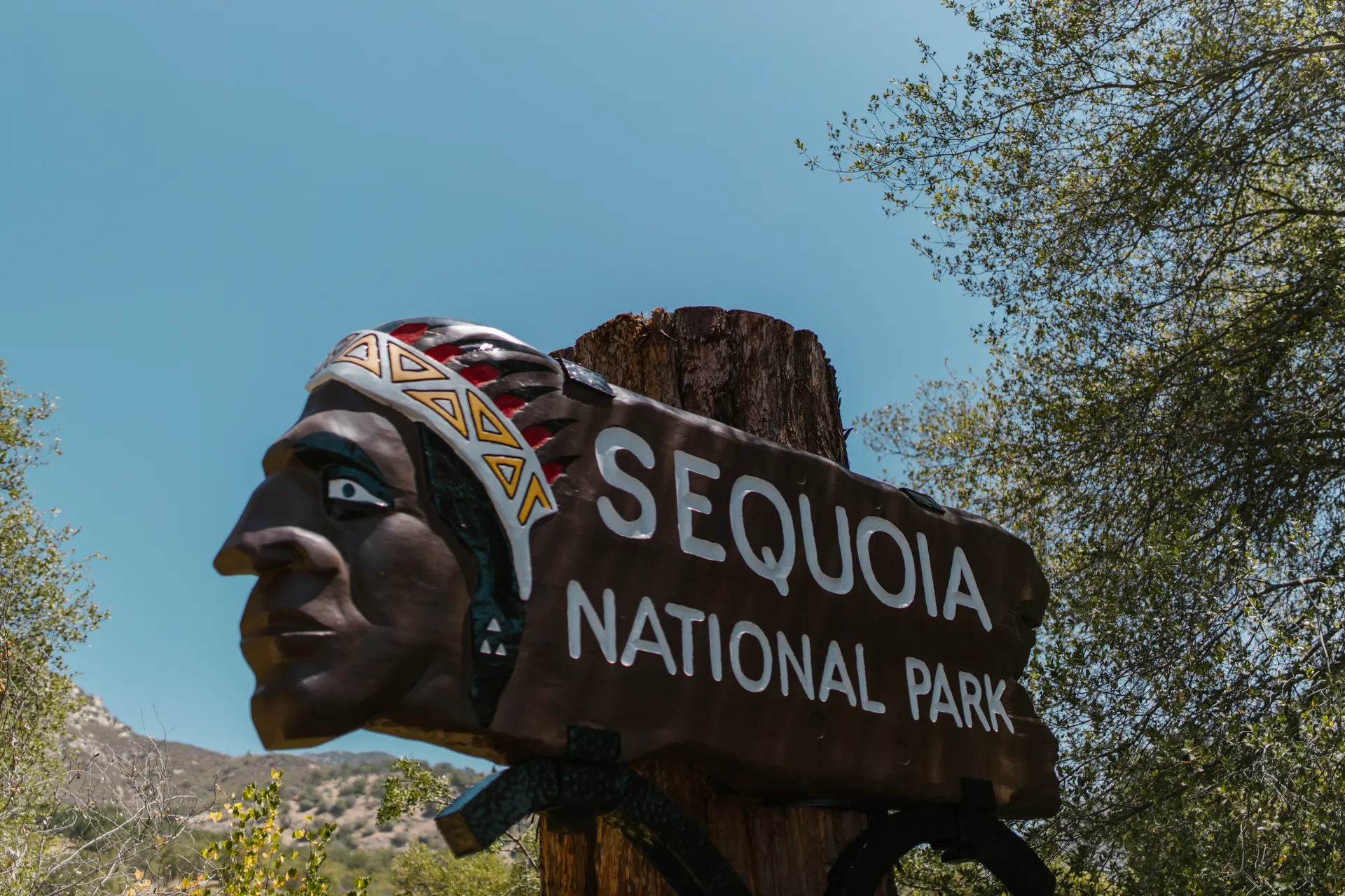 Close-up of Sequoia National Park entrance sign featuring a Native American motif. Close-up of Sequoia National Park entrance sign featuring a Native American motif.