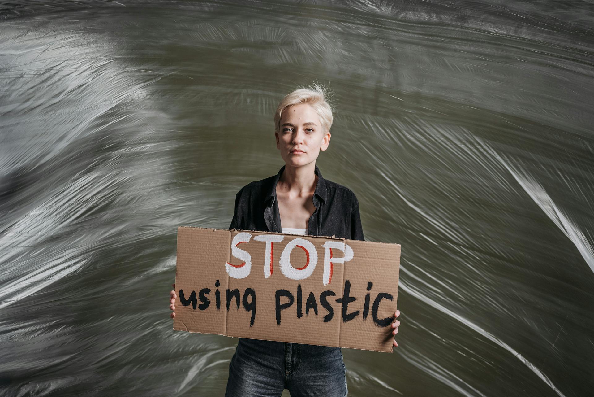 Portrait of an activist holding a sign against plastic usage, advocating for environmental change.