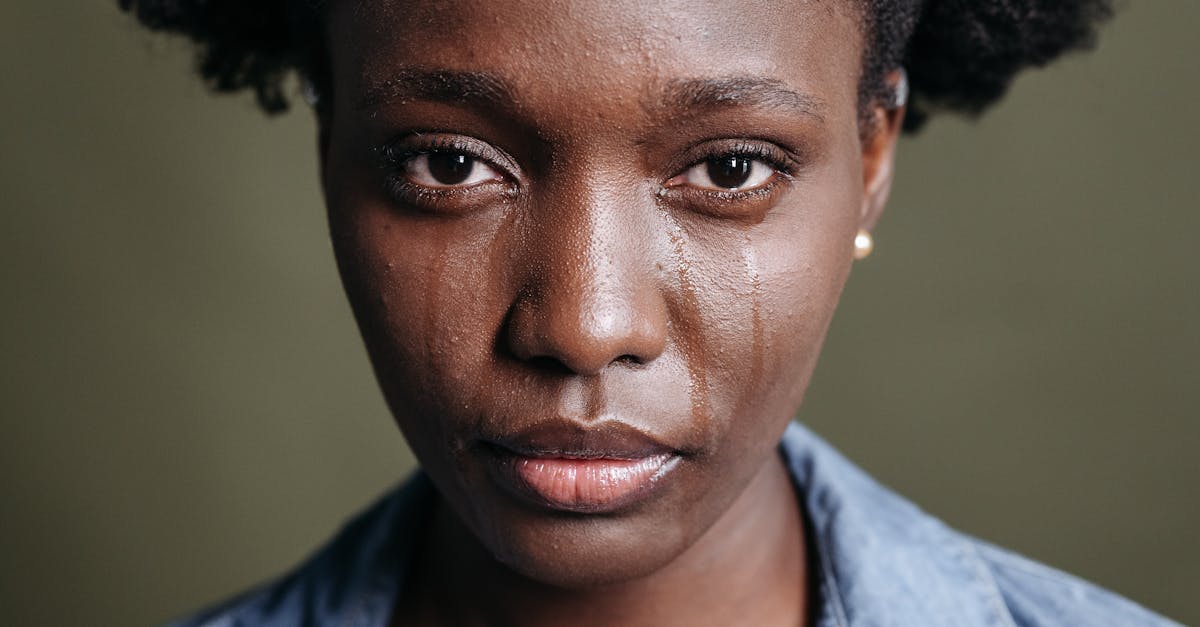 Close-up portrait of a woman with tears on her face, conveying emotion.