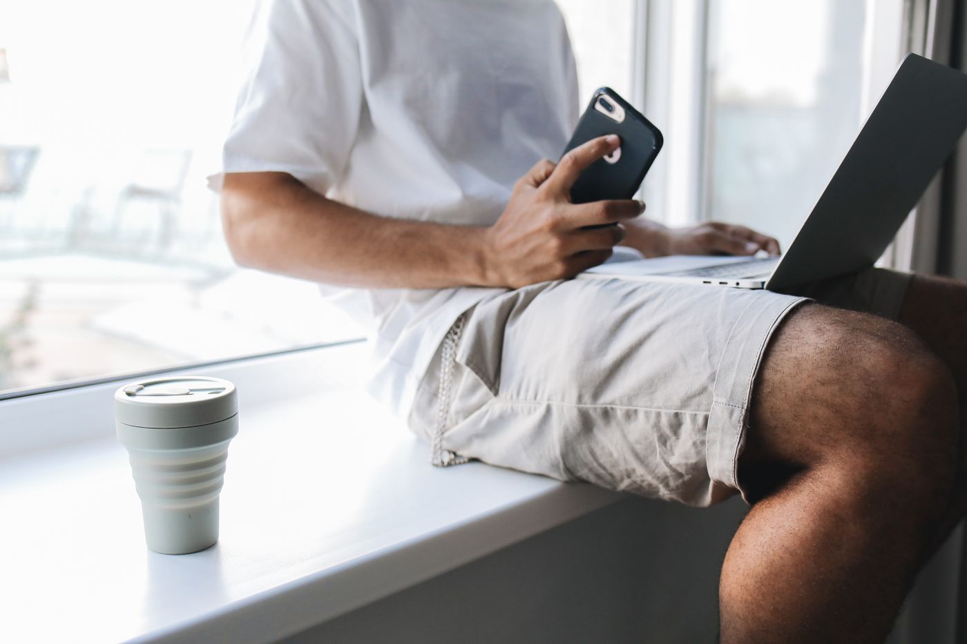 Person using a laptop and smartphone to manage online information