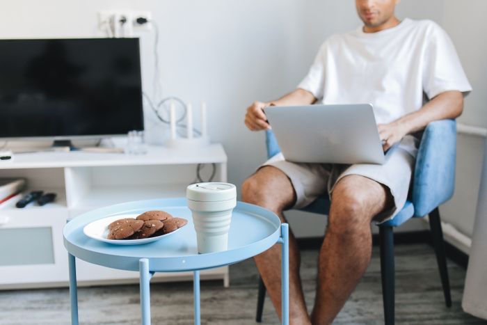 Person working on a laptop beside a small round table — photo by Polina Tankilevitch on Pexels
