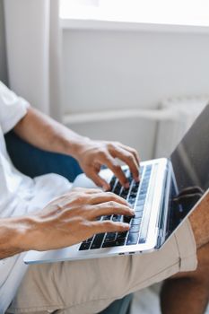 Close-up of a person typing on a laptop indoors, showcasing modern technology and lifestyle.