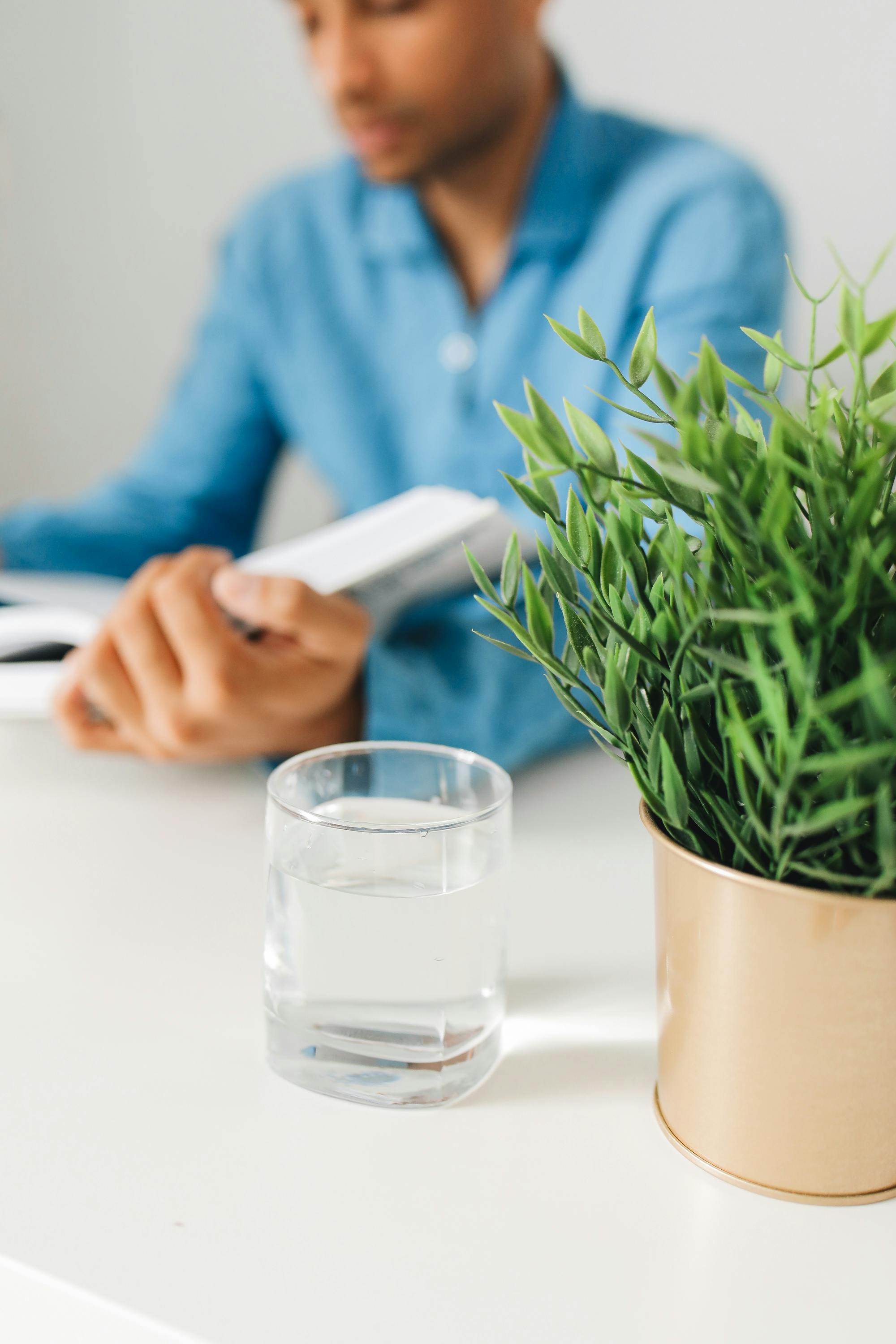 plant and water glass near man
