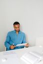 Man in Blue Dress Shirt Sitting on White Chair