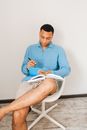 Man in Blue Dress Shirt Sitting on White Plastic Chair