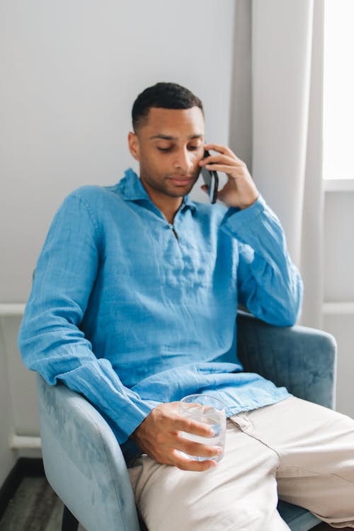 Free Man in Blue Long Sleeve Shirt on Phone Call Stock Photo