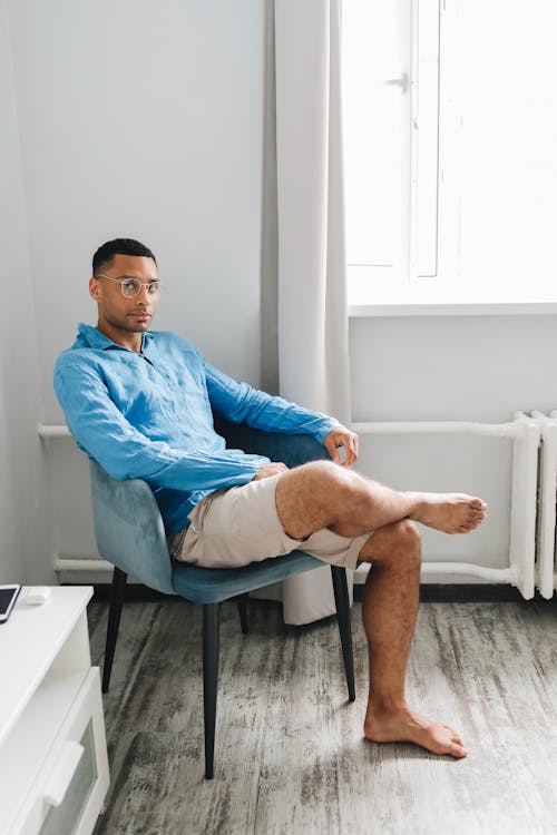 Free Man in Blue Top Sitting on a Chair Stock Photo