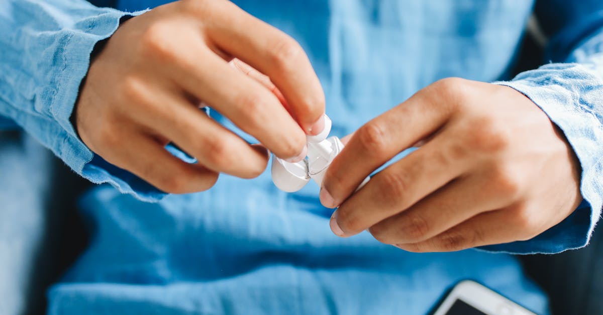 Person handling wireless earbuds in a casual setting, demonstrating practical use for evaluating fit and performance during ANC testing.