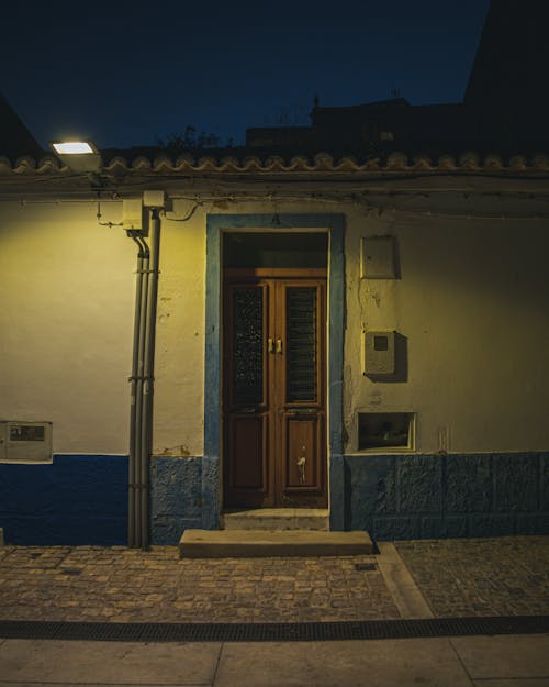 Brown Wooden Door Near Blue Concrete Wall