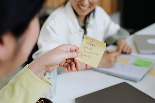Close-up of Woman Holding a Sticky Note with Handwriting 