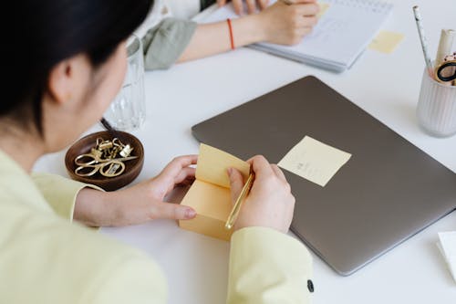 Close-up of Woman Writing on Sticky Notes 