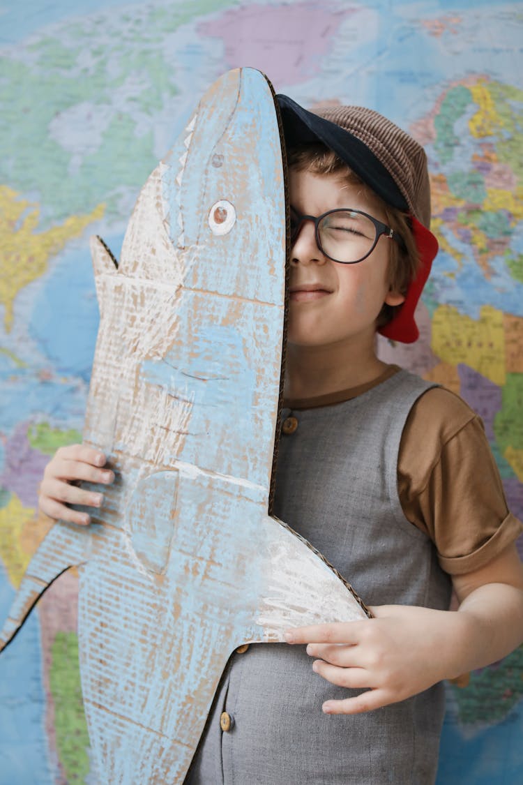 A Boy Holding A Cardboard Shark