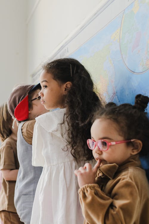 Kids Standing Near a Map