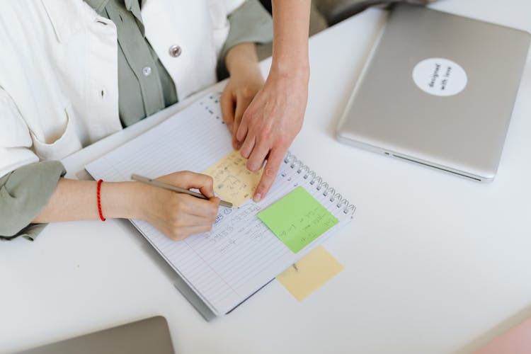 Person Writing On The Notebook