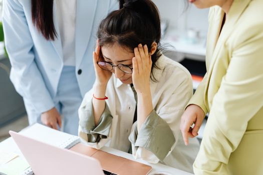 Team of businesswomen focused on solving a challenging work problem in an office setting.
