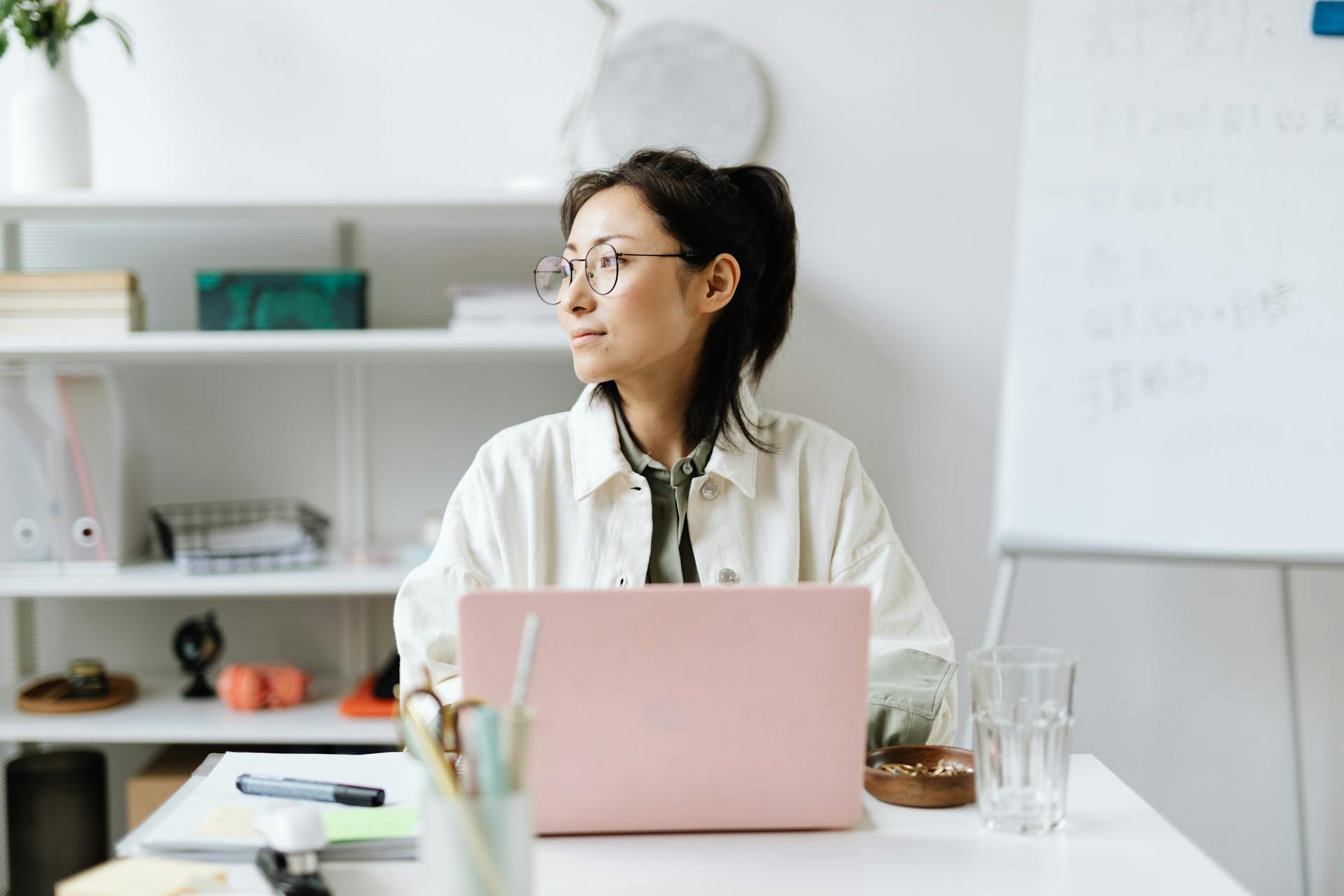 Woman Sitting by a Laptop in an Office