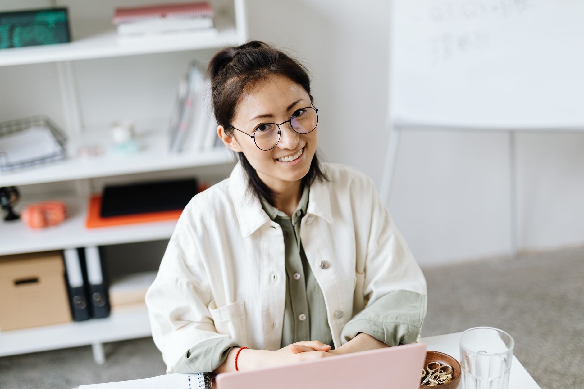 Smiling Woman Wearing Eyeglasses Sitting by the Laptop