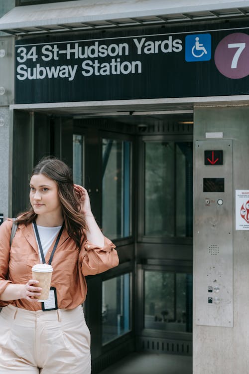 A Woman Standing by a Subway Station Entrance