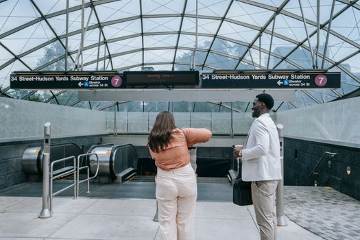 Business professionals standing at 34th Street-Hudson Yards subway entrance in New York City.