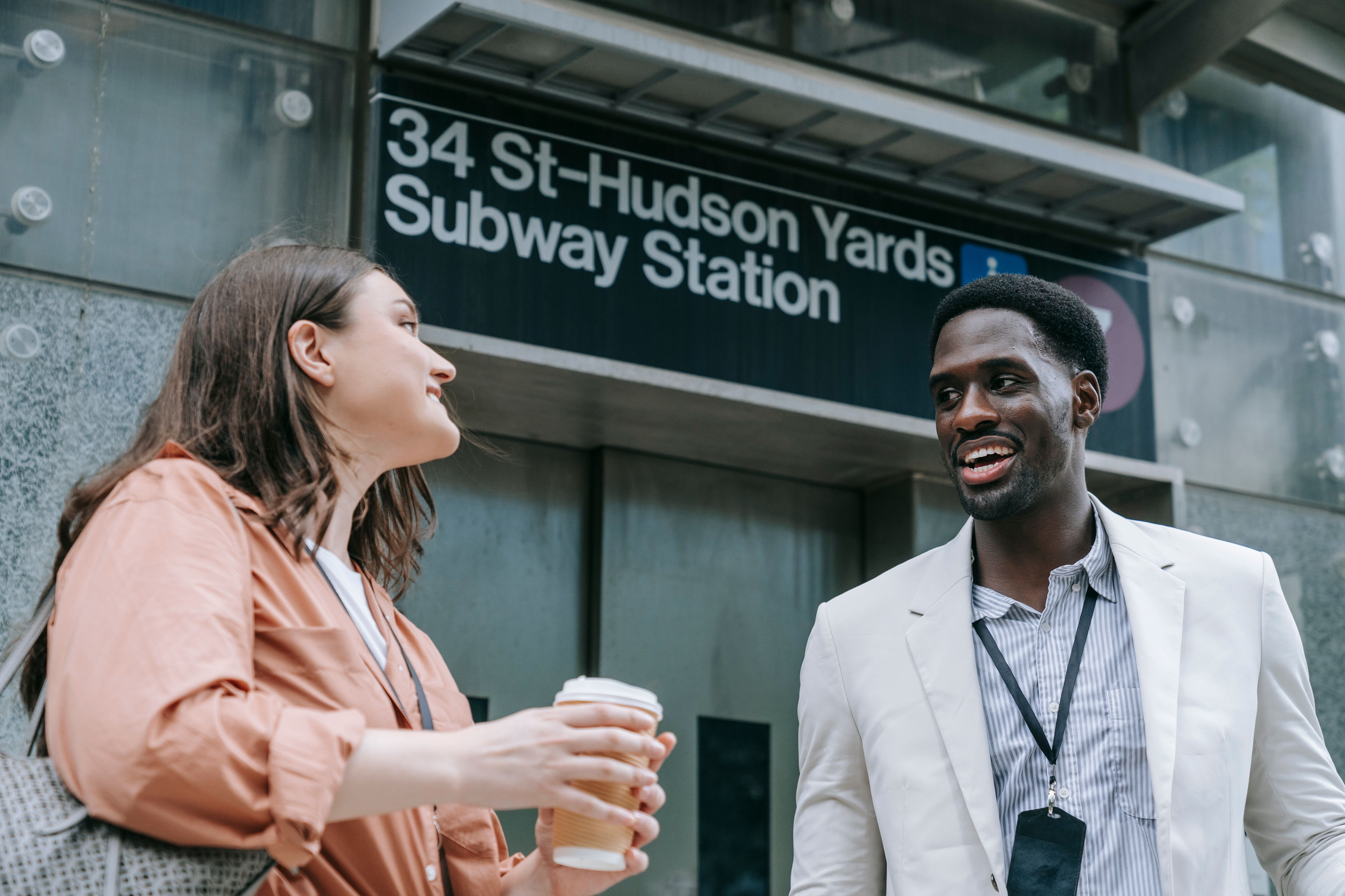 Two friends chat happily outside 34th St-Hudson Yards subway station.