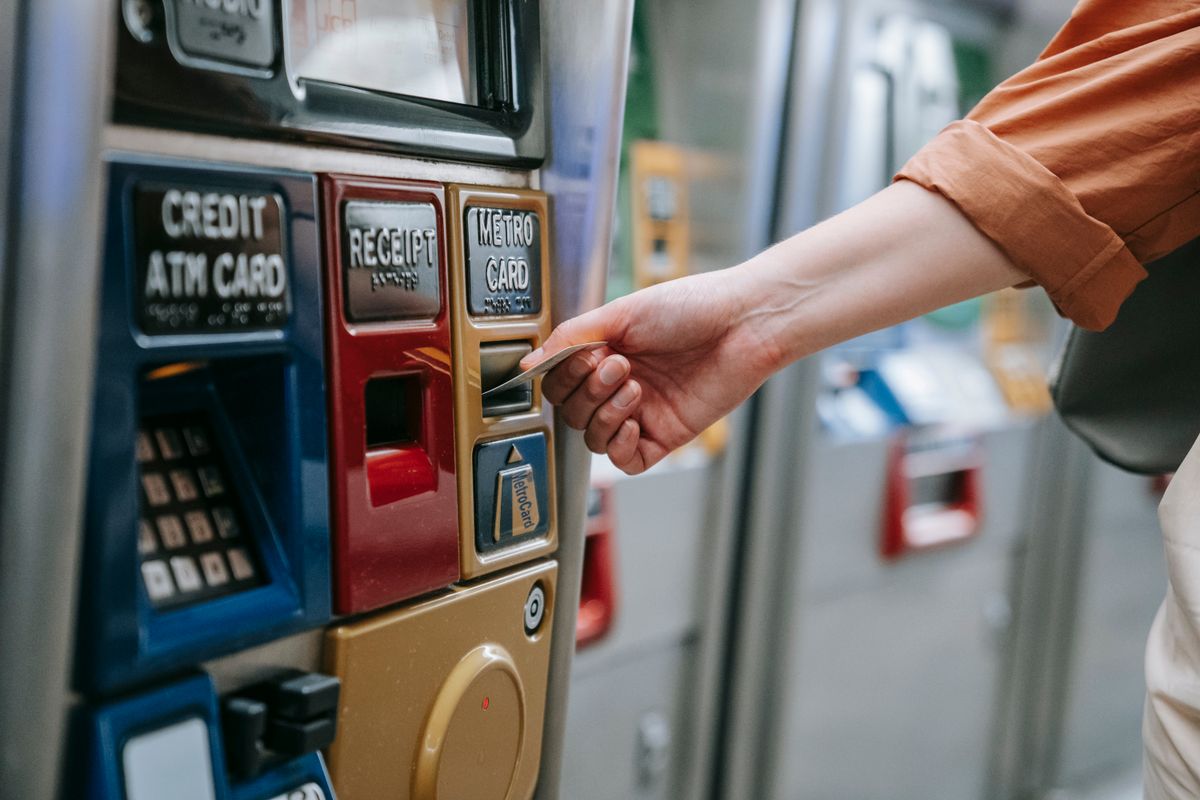 A person using an automated metro card machine for public transport payment
