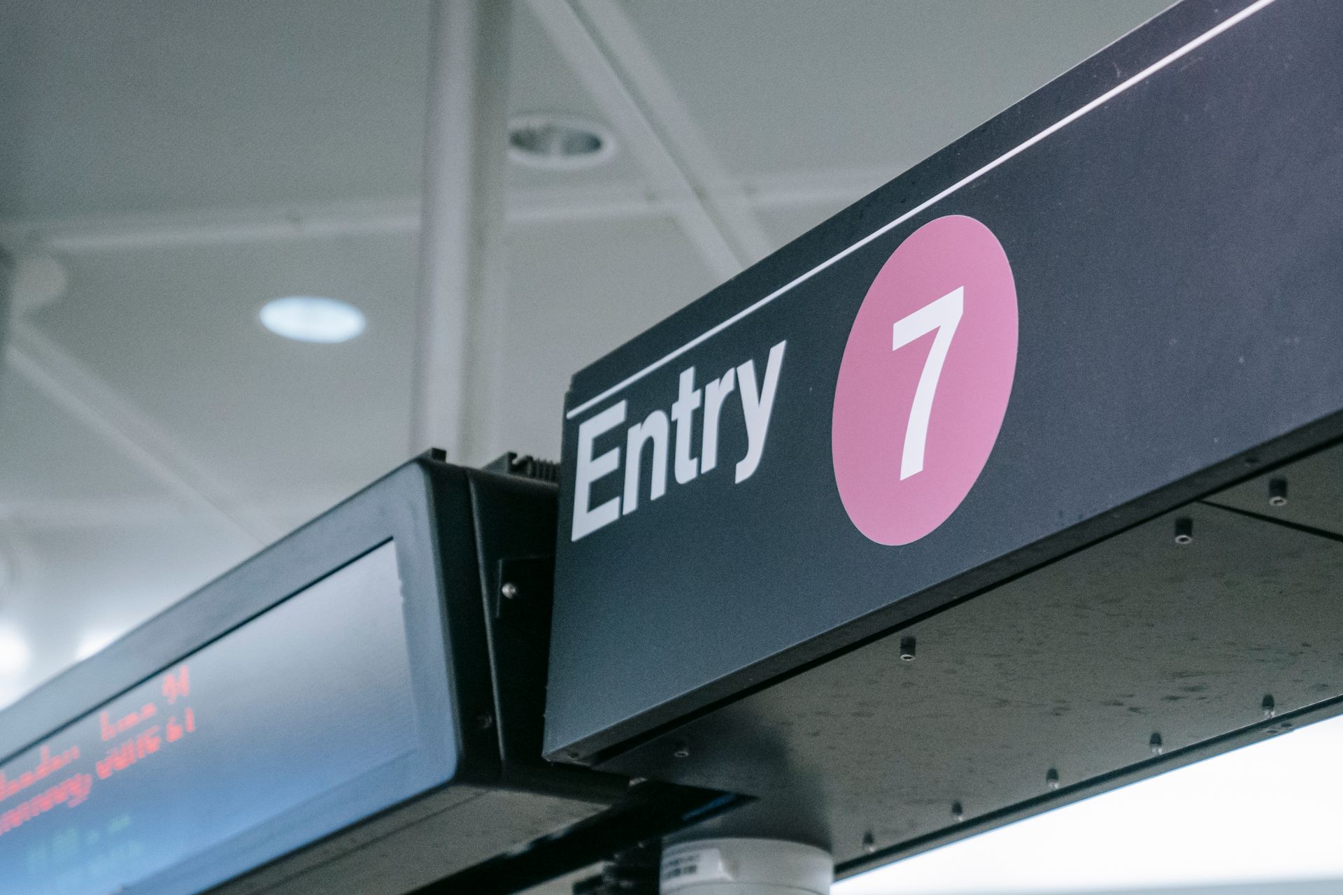 Detailed view of Entry 7 sign at a subway station, featuring modern signage.