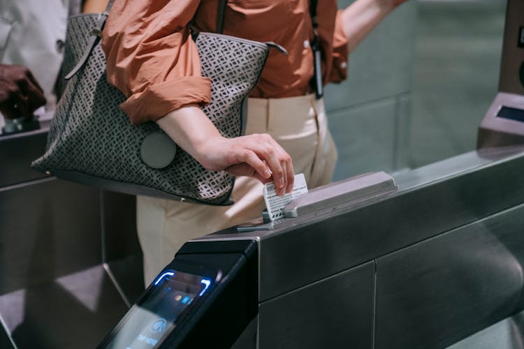 Close-up Of Woman Sliding The Card In A Subway Terminal 