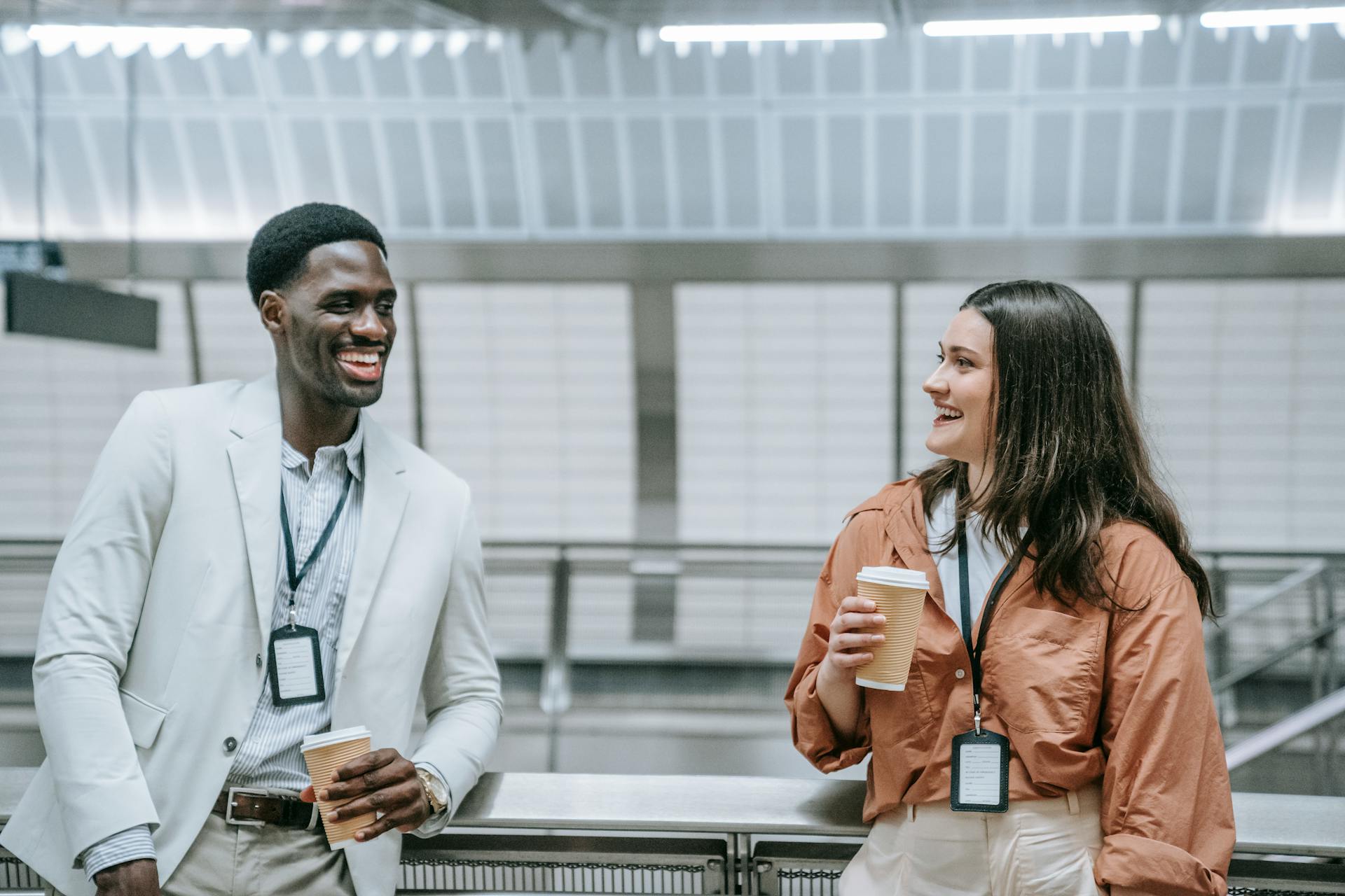 Man and Woman Wearing ID Badges Talking and Smiling