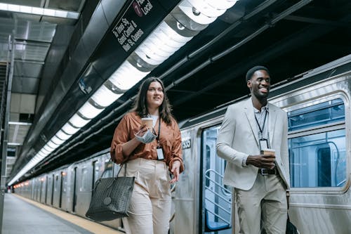 Free Man and a Woman Walking on Platform at the Train Station Stock Photo