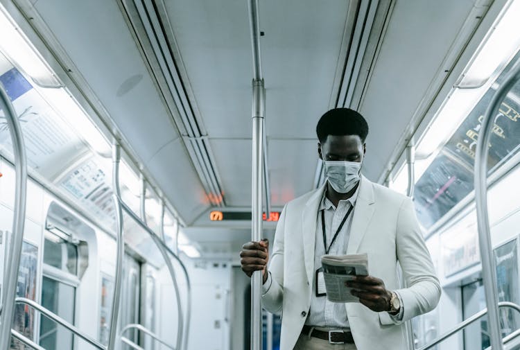 Person Reading Newspaper Inside The Train