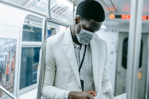 Close Up Photo of Man Wearing Face Mask Inside the Train