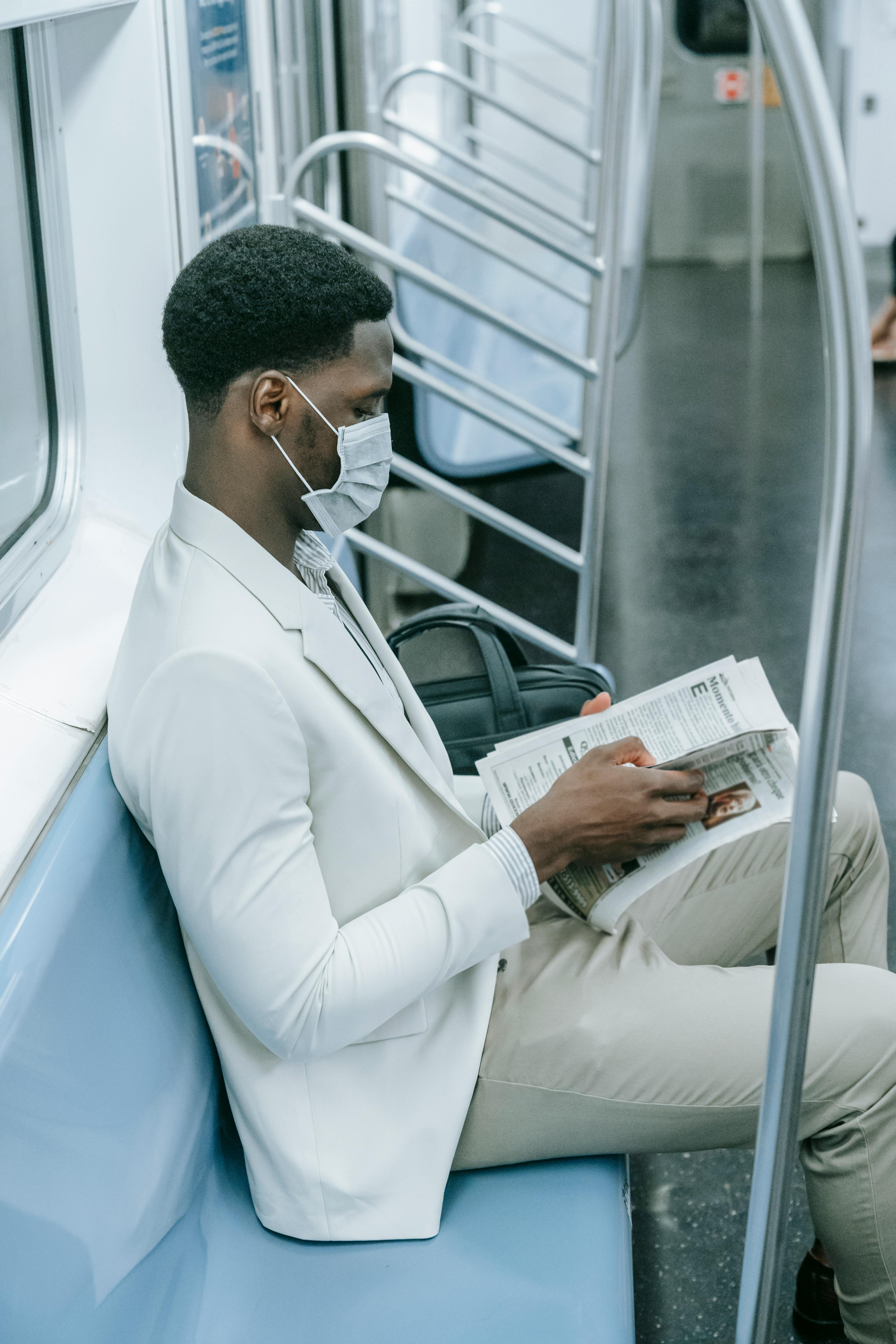 person reading newspaper while inside the train