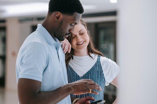 Close Up Photo of Couple Looking at the Screen of a Cellphone