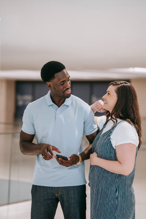 Man in Blue Polo Shirt Talking to a Woman