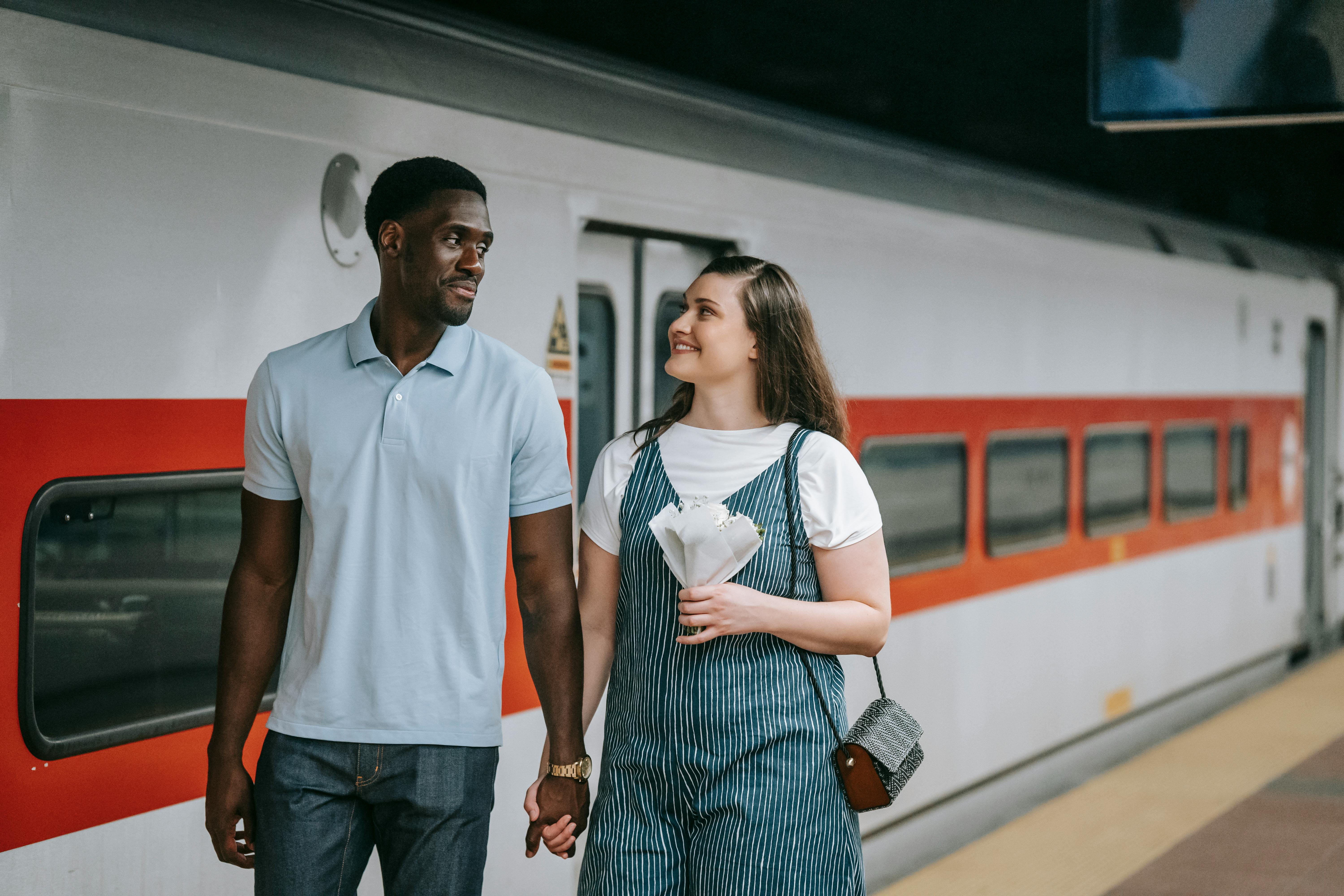 man and woman looking at each other at the train station