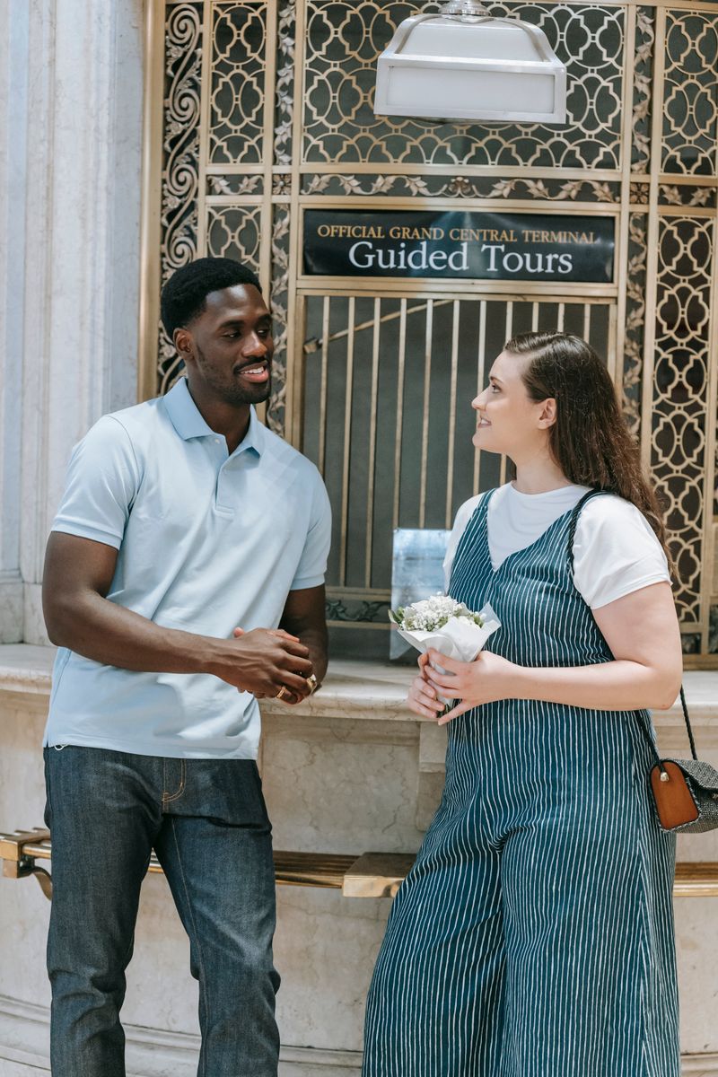 A cheerful interracial couple enjoys a conversation at Grand Central Terminal.